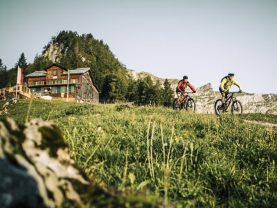 Mountainbiker mit Bayreuther Hütte im Hintergrund